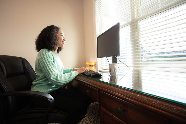 Woman in front of window using computer